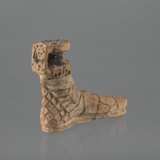 Foot-shaped aryballos, aryballos, antique vessel. Yellow-orange clay with mica; matte black engobe