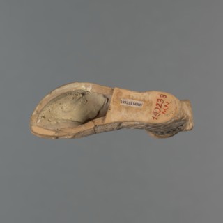 Foot-shaped aryballos, aryballos, antique vessel. Yellow-orange clay with mica; matte black engobe