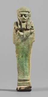 Ushabti, Mummy-shaped funerary figurine standing on a base, back supported by a pillar/pilaster.