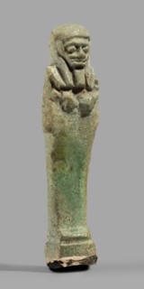 Ushabti, Mummy-shaped funerary figurine standing on a base, back supported by a pillar/pilaster.