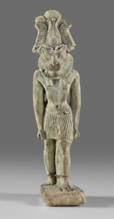Amulet - god Mahes. Figurine of a striding lion-headed male deity wearing an atef crown, dressed in