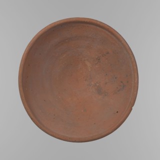 Bowl. Shallow, rounded, asymmetrical bowl with a rounded, flaring, irregular rim. Surface level;