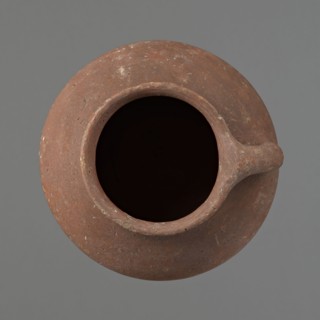 Jug. Small clay jug with one handle; wide, sloping shoulders, short neck widening toward a