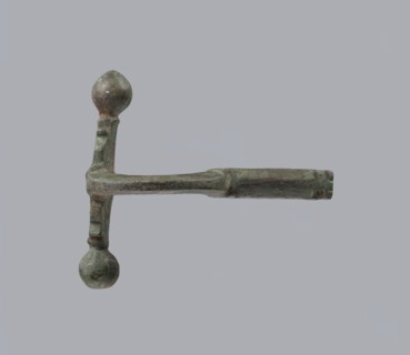 Onion-shaped fibula, Italy. Bronze fibula with a hinged structure featuring an arched ring made