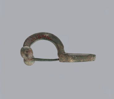 Onion-shaped fibula, Italy; bronze. A fibula with a hinged structure featuring an arched ring made