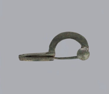 Onion-shaped fibula, Italy. Bronze fibula with a hinged structure and an arched ring made from a