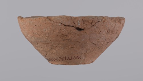 Bowl, probably votive, with a conical shape and a flat bottom. Straight rim, slightly curled