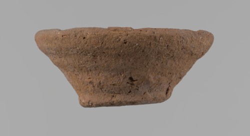 Bowl, probably votive, conical shape with a flat bottom. Irregular walls; straight rim slightly