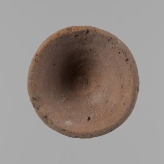 Bowl, probably votive, conical shape with a flat bottom. Irregular walls; straight, slightly