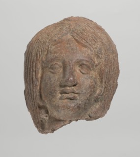 Female votive head, Female head with long, straight hair falling to the shoulders. Neck partially