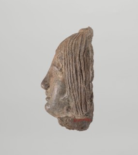 Female votive head, Female head with long, straight hair falling to the shoulders. Neck partially