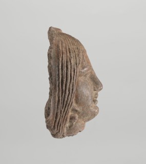 Female votive head, Female head with long, straight hair falling to the shoulders. Neck partially