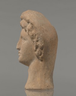 Female votive head, Female head in a wreath, slightly tilted to the right shoulder. Under the