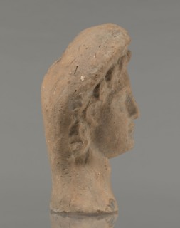 Female votive head, Female head in a wreath, slightly tilted to the right shoulder. Under the