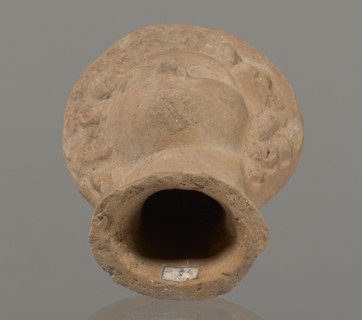 Female votive head, Female head in a wreath, slightly tilted to the right shoulder. Under the