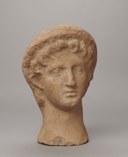 Female votive head, Female head in a wreath, slightly tilted to the right shoulder. Under the