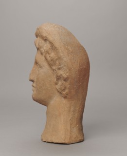 Female votive head, Female head in a wreath, slightly tilted to the right shoulder. Under the