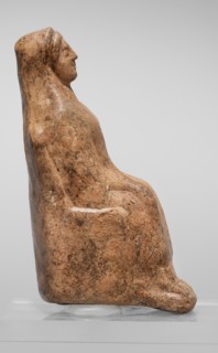 Figurine of a seated woman. Figurine of a woman sitting on a throne with her hands placed on her