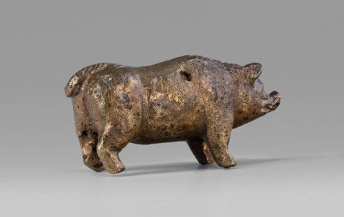 A small bronze figurine of a pig. The animal stands on rather schematically depicted legs ending in