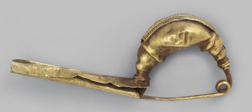 Leech fibula with an elongated stem. Swollen, profiled ring at the ends decorated with a long strip