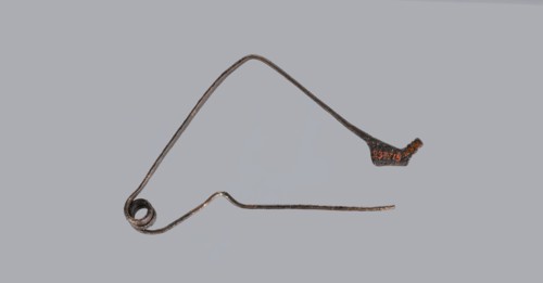 Bronze Etruscan fibula with a bent ring made of flatly beaten wire, passing in a three-turn spiral