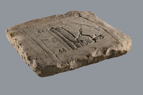 Rectangular tombstone depicting a young man in a long robe in a semi-reclining position on a bed