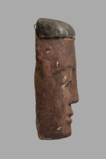 Sarcophagus mask with a flat fragment of a wig above the forehead. Elongated face, painted brown,