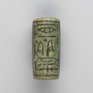 Cylinder seal with pseudo-hieroglyphs, A cylindrical seal with a hole drilled along the cylinder.
