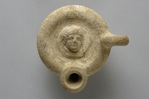 Guttus, top decorated with a plastic medallion with the image of a woman's head shown