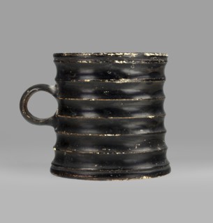 Dice cup. Small cup with a flat slightly concave bottom, slightly tapered walls, distinct rim and