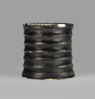 Dice cup. Small cup with a flat slightly concave bottom; slightly tapered walls and distinct rim.