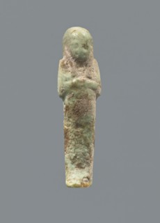 Ushabti, mummy-shaped figurine; funerary gift; hoes. Hands folded on the chest, uncrossed, right