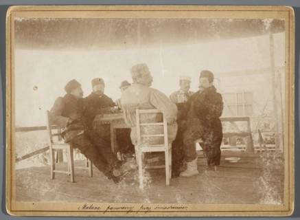Six painters seated at a table on the central platform in the rotunda painting the Raclawice