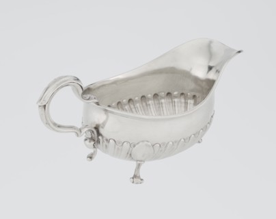 Oval gravy boat, supported on three volute legs, S-shaped handle; wide rim on the axis. Bottom