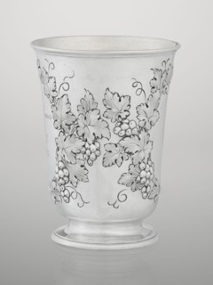 Conical mug, silver on circular foot; belly decorated with relief vine wreaths, one with an English