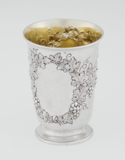 Conical mug, silver on circular foot; belly decorated with relief vine wreaths, one with an English