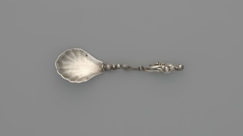 Decorative silver spoon with a shell-shaped scoop and handle formed by a solid dolphin supporting a