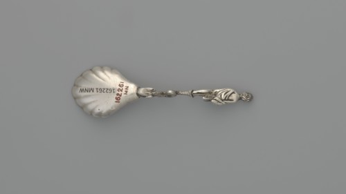 Decorative silver spoon, shell-shaped scoop, handle formed by a solid dolphin supporting a naked