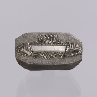 Jewellery die, Approximately hexagonal die with a relief rectangular reserve enclosed at the ends