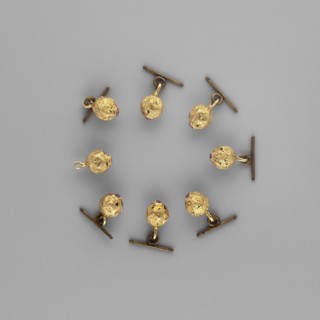 Buttons for a zupan with clasps. Nearly spherical, polygonal buttons with engraved four-leaf