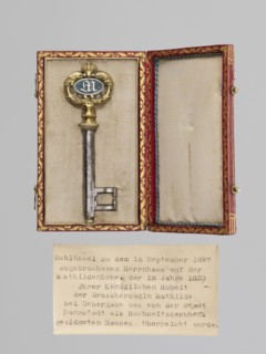 Rectangular key case with a hinged lid and two clasp hooks. Trimmed with red leather, with gilded