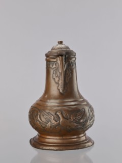 Jug. On a circular, stepped base, the body bulges in the lower part, decorated with a repoussé