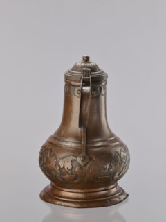 Jug. On a circular, stepped base, the body bulges in the lower part, decorated with a repoussé