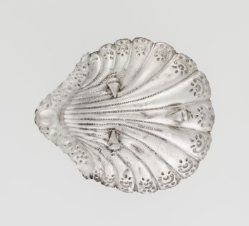 Platter in the form of a full-plastic scallop shell, knotted and ribbed, decorated on the rim with