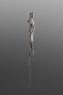 Fork. Two-pronged steel fork with a silver handle in the form of a full-plastic female herm.