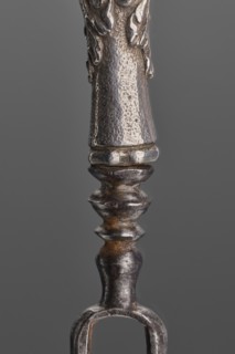 Fork. Two-pronged steel fork with a silver handle shaped as a full-plastic female herm. Unmarked.
