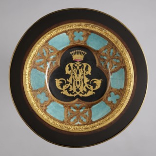Round table, lacquered black, decorated with gilded cast brass fittings, with a ceramic painted