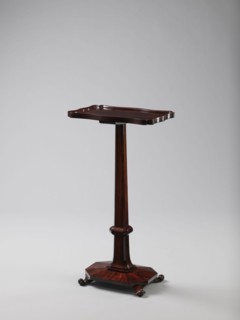 Pedestal table with a rectangular top with a wavy-cut edge and a low wooden gallery, supported by