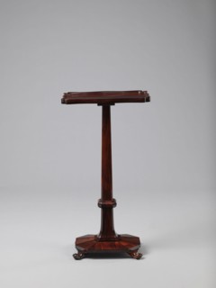 Pedestal table with a rectangular top with a wavy-cut edge and a low wooden gallery, supported by