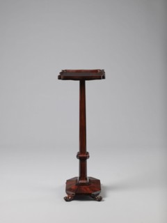 Pedestal table with a rectangular top with a wavy-cut edge and a low wooden gallery, supported by